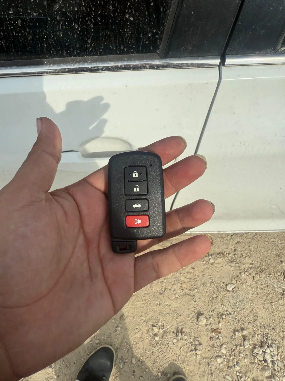 vehicle key fob checked beside a car, real company service photo 1